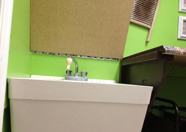 Laundry folding countertop hinges open to reveal utility sink 4